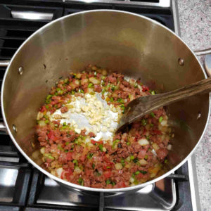 Note how the water released from the onion can deglaze the pot. Add garlic and the other herbs and spices.