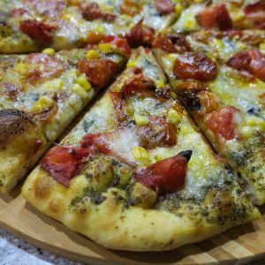 Can you say summer? Pizza with roasted cherry tomatoes, corn and blue cheese, all on Pesto!