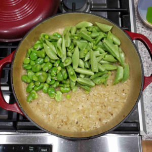 After 40 minutes, remove from the oven and stir in the peas and fava beans.
