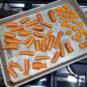Slice one carrot into coins and chop the others into large pieces averaging 1/2" thick. Toss in salt and olive oil and spread on a baking sheet.