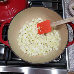 In a medium sized enamled cast iron Dutch oven, auté finely diced onions in olive oil, until translucent.