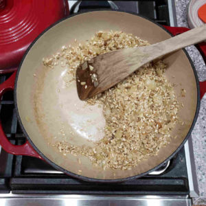 Add a splash of white wine. Deglaze any fond that has developed and stir until the wine is absorbed by the rice.