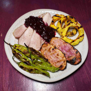 Mixed grill featuring pork secreto and blueberry chutney.