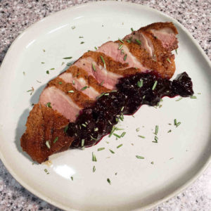 Duck breast with blueberry chutney and rosemary.