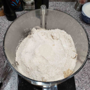 If necessary, spread the clumped mixture around teh bottom of the food processor, and add the remaining 1/3 of the flour mixture.