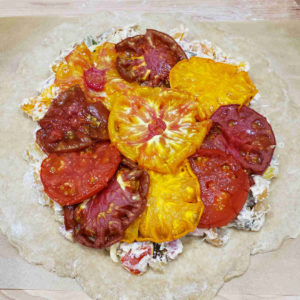 Don't mix the roasted tomatoes with the other ingredients. Instead layer them on top before adding the final cheese and folding the dough around the edges.