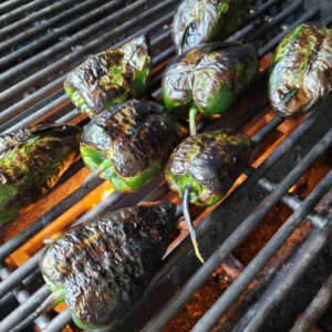 Poblanos charring on the grill.