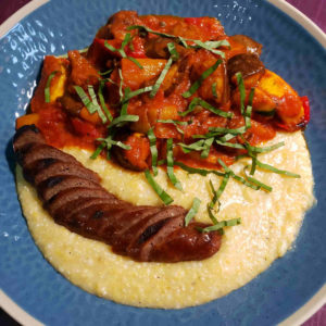 Roasted vegetable ratatouille, served with polenta and a link of merguez sausage.