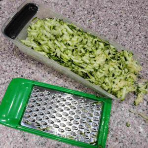 Start by grating up a full pound of zucchini or other summer squash.