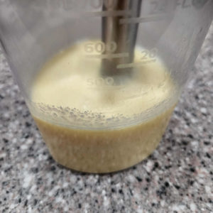Add two ounces of pasta cooking water to the jar and blend it up with an immersion blender.