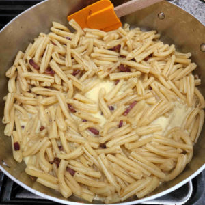 Pour the egg mixture into the skillet along with the pasta and start to stir continuously.