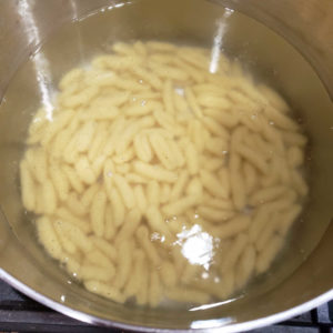 Bring about 5 quarts of salted water to a rolling boil and add the pasta. Expect the boil to temporarily stop and the pasta to sink to the bottom. Stir to prevent sticking.